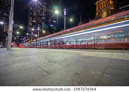 Tram moving through George St at night leaving colourful light trails Sydney NSW Australia