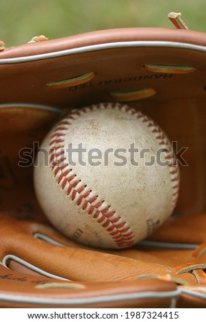 Baseball in a glove on a field