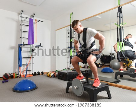 Handsome male working out on eccentric machine Royalty-Free Stock Photo #1987338185