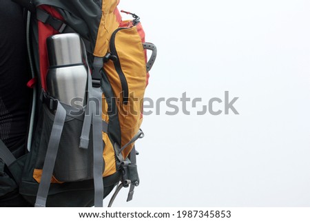 Steel thermos in the pocket of the backpack. Tourist Traveler bag. Adventure Walk.