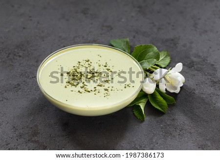 Vegan dessert, Panna Cotta green matcha tea in a glass bowl on a dark gray background