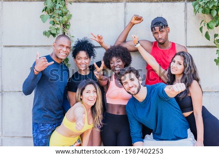 Portrait of a group of runners smiling at camera with raised fists.