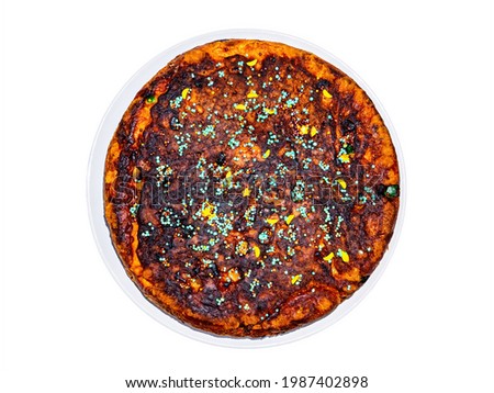Round dough pie decorated with colored sprinkles. Cake dough. Sweet dessert. Homemade baking. Confectionery. Sweet food. White background. Soup plate. Background picture.