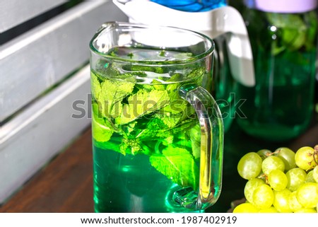 summer refreshing drink in a transparent jug. mojito with fresh mint