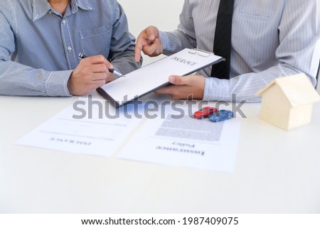 Sales manager giving advice application form document, considering mortgage loan offer for car and house insurance