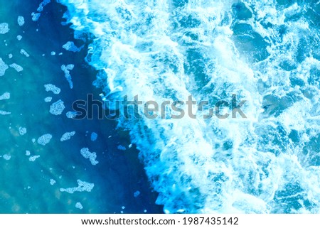 Areal shot of deep blue and rough sea with lot of sea spray.Blue background.Soft focus,blurred image.