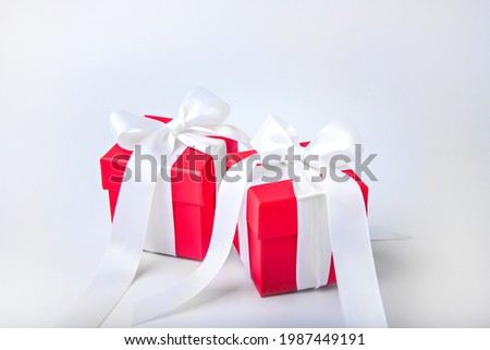 Two red gift boxes with white bows.