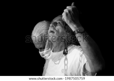 old man with white hair on black background.