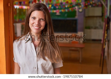 Young woman as a happy educator or kindergarten teacher in a day care center or after-school care center Royalty-Free Stock Photo #1987510784