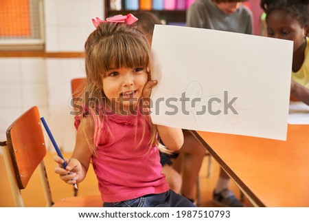 African girl painting a picture in the creative painting course in the international kindergarten