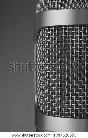 Closeup of a gray microphone on gray background