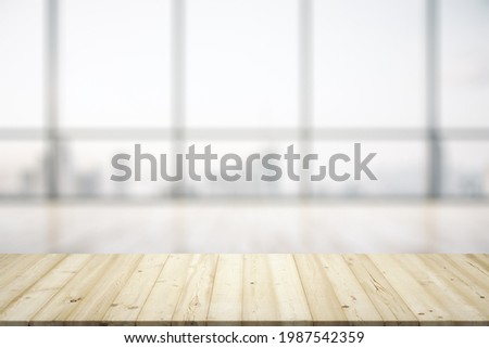 Empty wooden table with light sunny office interior with large window on background, mock up