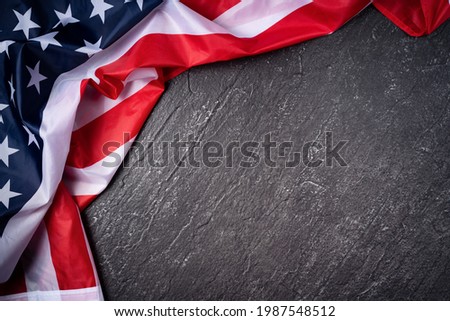 Concept of U.S Independence day or Memorial day. National flag over dark slate table background.