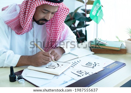 Arab men practicing writing Arabic ้with bamboo pens and ink on paper, Arabic letters mean the name of Muslim god "Allah", handwriting Khat