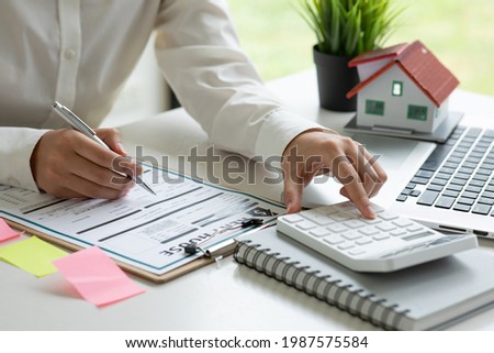 Close up house model with business woman signs a purchase contract or mortgage for rent a home, Real estate concept.