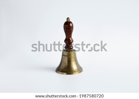 The old-style hand bell with a wooden handle and probably a brass body was used as a break bell in schools. Royalty-Free Stock Photo #1987580720