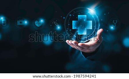 Businessman holding virtual plus sign or cross mark with healthcare icons , insurance concept.