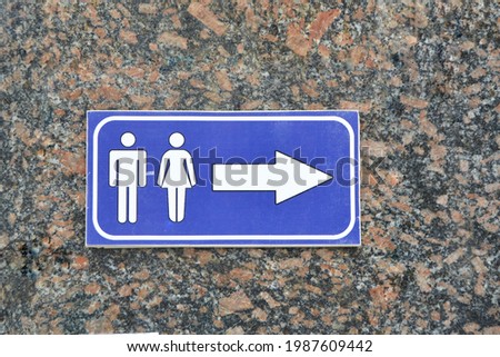 modern public toilet sign And Direction on marble wall. Background of stone texture.