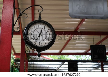 old retro clock hanging on a column in the bus station corridor