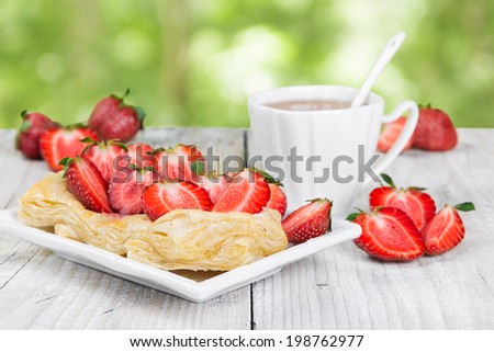 Dessert with strawberries on a white plate, outdoors 