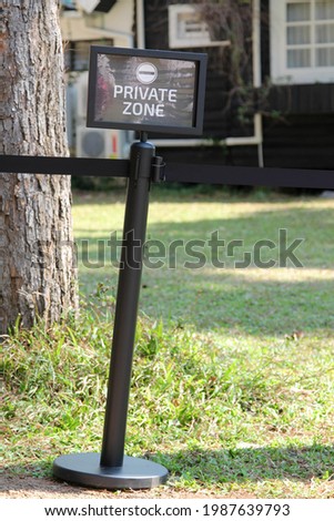 Sign for "PRIVATE ZONE"  on green grass.