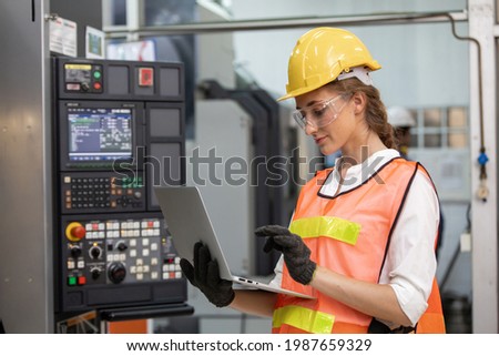 Engineer and worker control and check robot working in factory. The worker is controlling the robot to work in the factory. female factory worker.  Engineer women are working with machines cnc