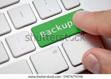 Online backup concept;Close-up of green color typing backup of male hand pressing computer keyboard. Royalty-Free Stock Photo #1987674146