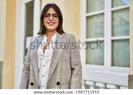 Young hispanic businesswoman smiling happy standing at the city.