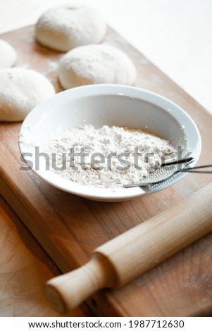 Cooks roll dough for baking, pieces of raw dough on wooden Board