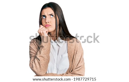 Young brunette teenager wearing casual white shirt and jacket looking stressed and nervous with hands on mouth biting nails. anxiety problem. 