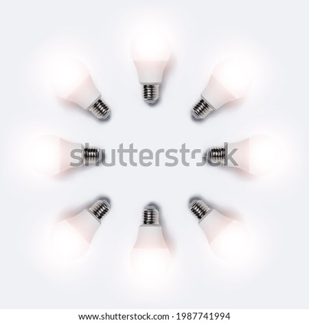 Many glowing light bulbs in shape of circle isolated on white background. Business idea concept.