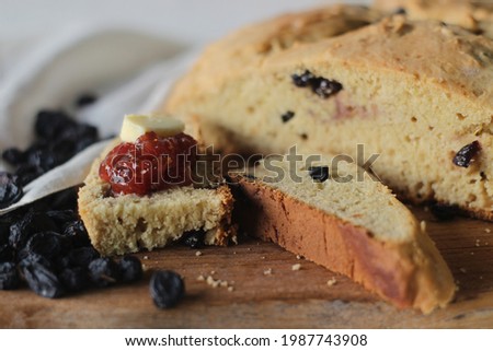 Slices of home baked Irish soda bread with raisins. A quick bread to make at home with out yeast. Served with fig jam. Shot on white background. Royalty-Free Stock Photo #1987743908