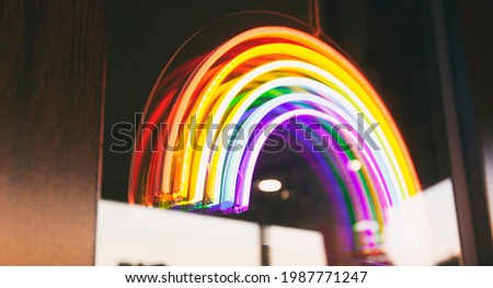 The led neon rainbow hanging on the door entrance in the cafe