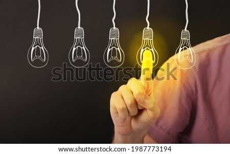 Man hand touching light bulbs new ideas with index finger isolated on black background. High resolution photo.