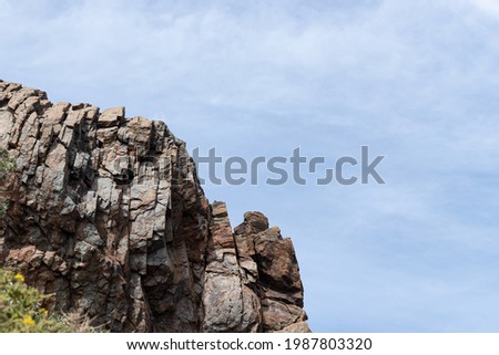 Old rock on the background of blue sky. Nature wallpaper