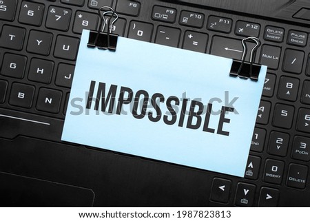 Impossible inscription on white paper note on laptop keyboard. Closeup message.