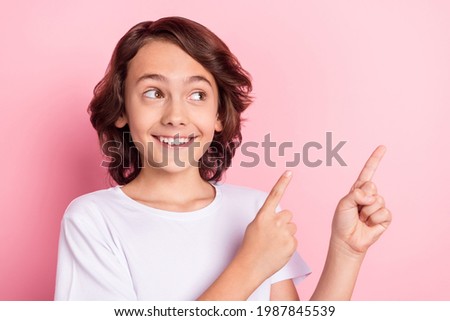 Photo of cheerful amazed young boy look point fingers empty space sale news isolated on pink color background