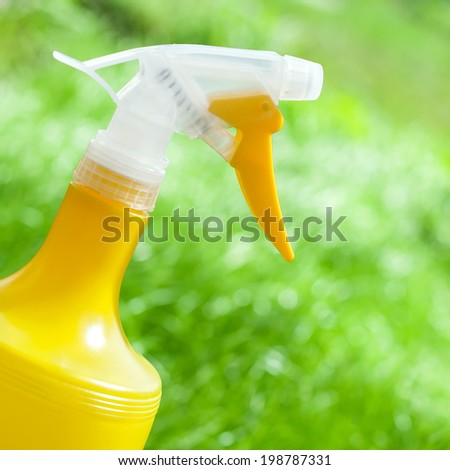 Gardening tools. Plastic watering yellow can with spray on grass background