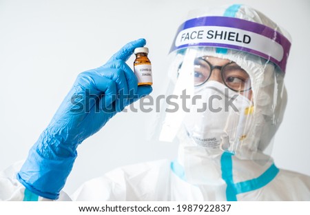 Healthcare worker holding and looking a bottle of covid-19 vaccine. Vaccination is one of the most effective ways to prevent diseases and helps the body’s immune system from virus.