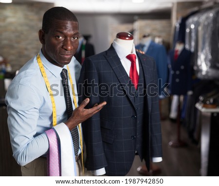Afro-american man buyer in shirt choosing colored tie in the dress shop. High quality photo