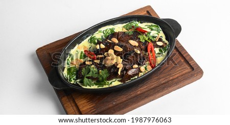 Meat with vegetables served with sauce in a pot over white background. Rustic style dinner, Ukrainian cuisine concept.