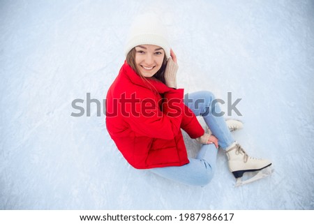 Happy smile woman in winter with skates on outdoors ice rink sunset.