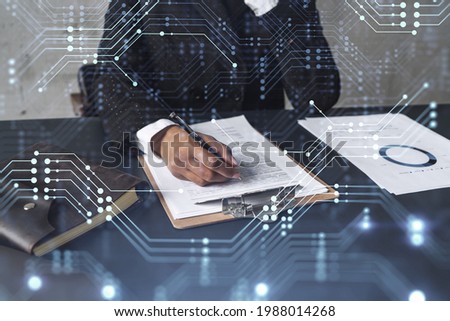 African American businesswoman is signing a contract to create a new software to present it in start up conference and gain investments to create a product. Technological graph over the desk.