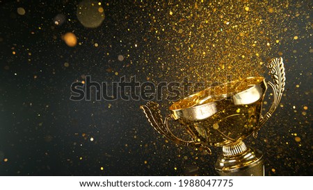 Champion golden trophy isolated on black background. Concept of success and achievement. Royalty-Free Stock Photo #1988047775