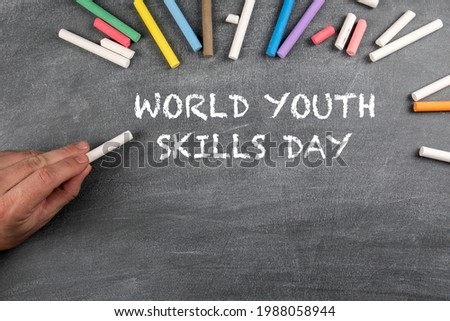 World Youth Skills Day 15 July. Colored pieces of chalk on a background of a dark chalk board.