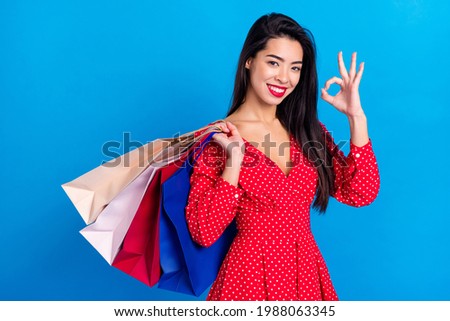 Photo portrait of woman keeping packages in shopping mall showing okey sign isolated on vibrant blue color background