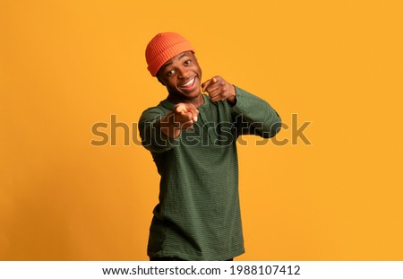 Positive Young African Hipster Guy Pointing At Camera With Two Hands And Saying Gotcha, Cheerful Black Millennial Man Indicating Somebody, Having Fun Over Yellow Studio Background, Copy Space Royalty-Free Stock Photo #1988107412