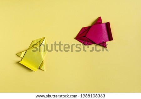Concept paper cars in yellow and red on a colored background close-up. Origami colored paper racing cars	