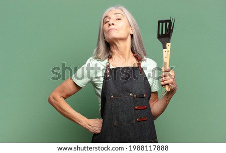 gray hair pretty  barbecue chef woman Royalty-Free Stock Photo #1988117888