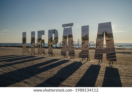 Liepaja city title at Baltic beach. Big mirroring letters in sunny evening.  Royalty-Free Stock Photo #1988134112
